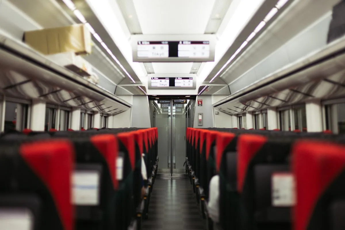 Empty red seats inside a Japanese train with a display showing Tokyo