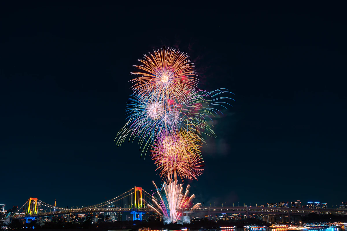 Spectacular fireworks lighting up the night sky over Tokyo's Rainbow Bridge