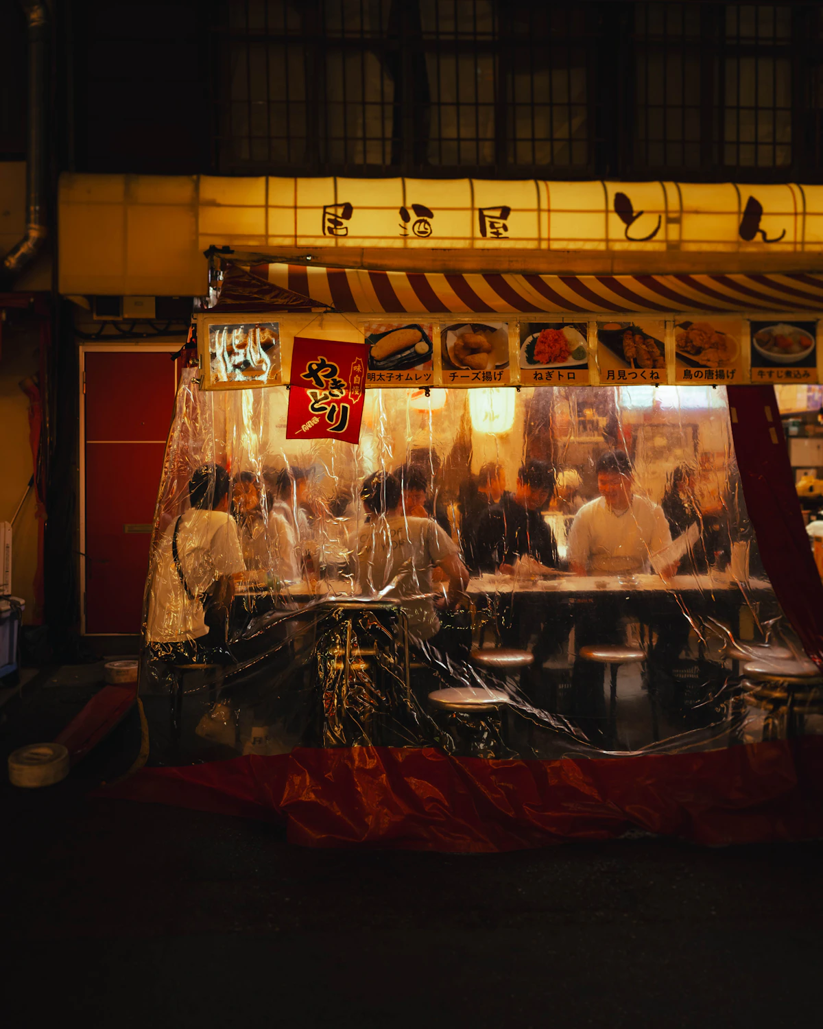 People enjoying a meal at a small yakitori izakaya in Asakusa