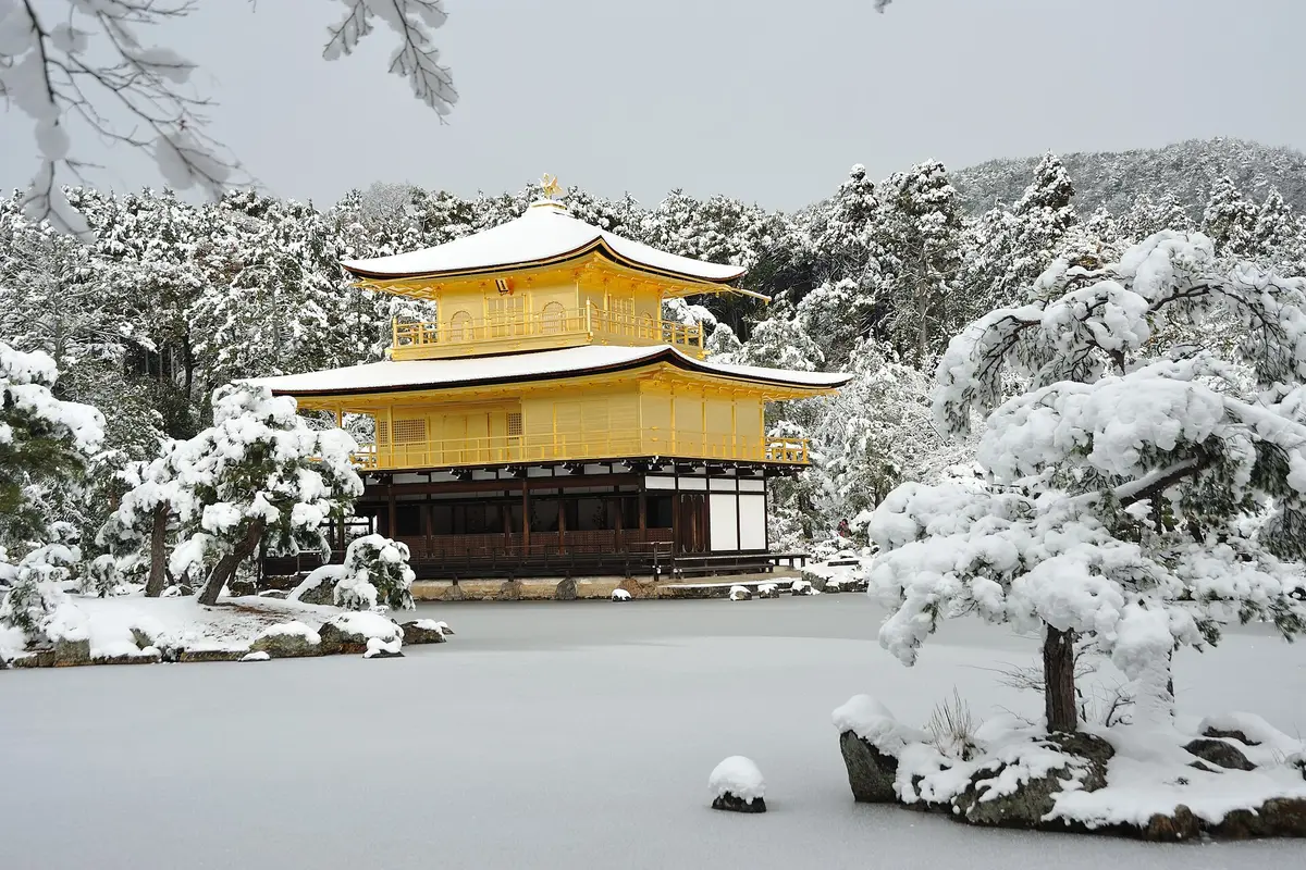 Under fresh snow: the gold pavilion of Kinkaku-ji with white roofs, standing above a snow-covered pond