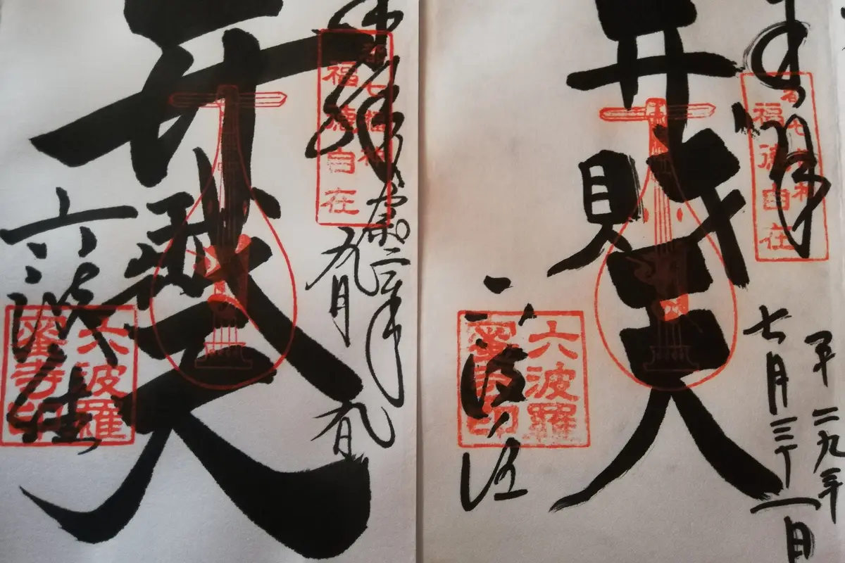 Two goshuin brushed in black ink over vermilion seals on the facing pages of a stamp book