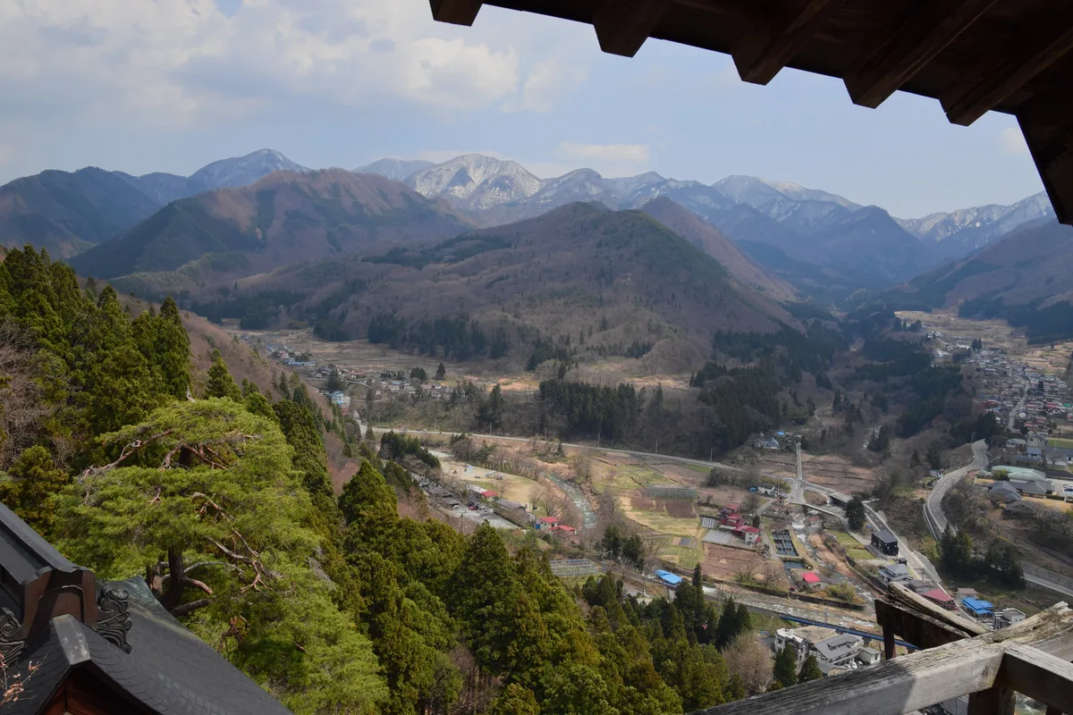 View from the Godaido hall's wooden eaves over the forested Tachiya river valley and the town of Yamadera below