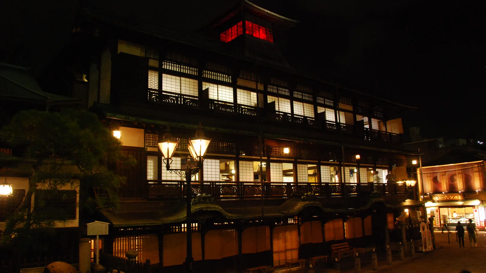 The Shinrokaku tower of the Dōgo Onsen Honkan, lit at dusk