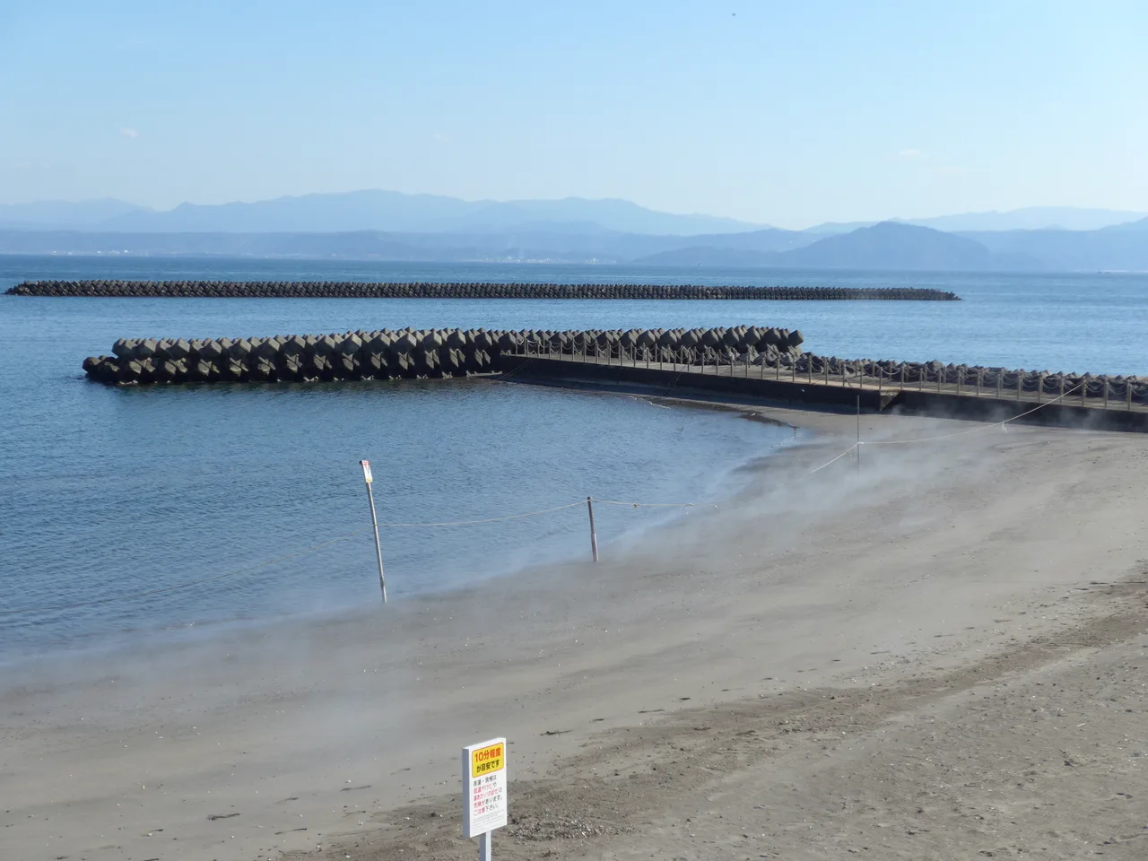 A coastal hot-spring town south of Kagoshima with steam drifting along the shore, the volcanic heat that warms the famous sand baths