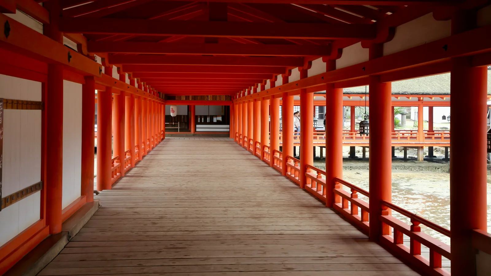 A vermillion corridor of Itsukushima Shrine built on stilts above the water