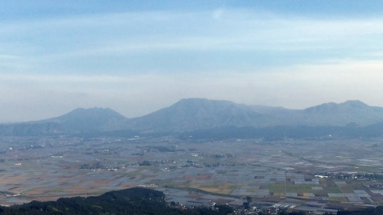 The view from Daikanbo lookout down into the Aso caldera, with the five peaks of Mount Aso rising from the valley floor