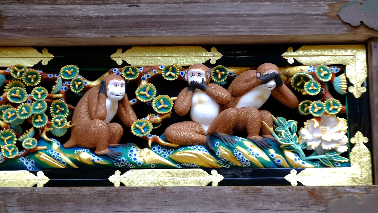 Carved monkeys on the wooden eaves of the Shinkyusha sacred stable at Nikko, including the famous see-no-evil, speak-no-evil, hear-no-evil panel