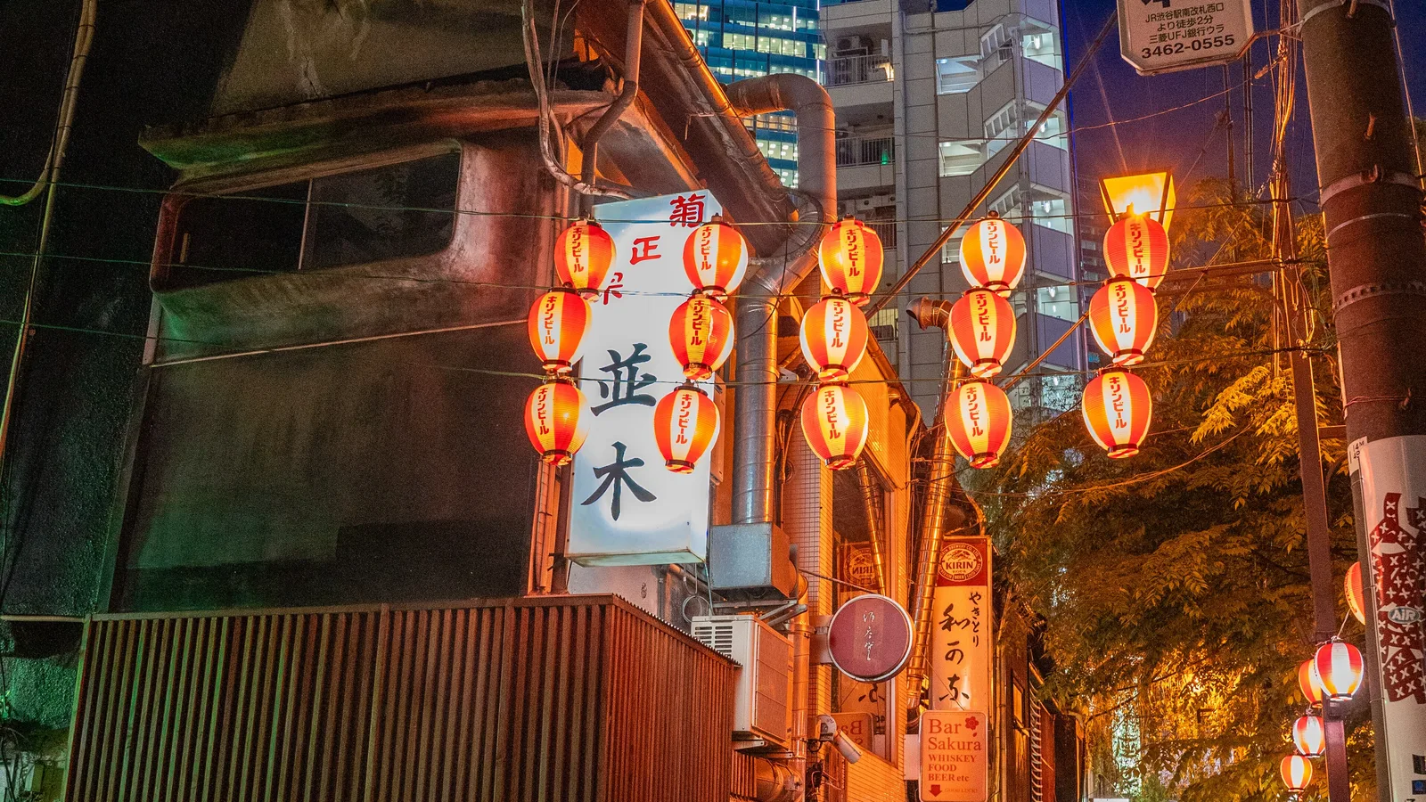 A narrow lantern-lit alley of tiny bars near Shibuya Station