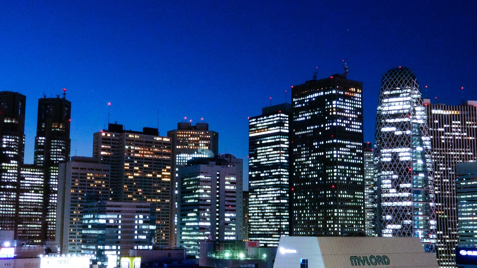 The skyscrapers of Nishi-Shinjuku, including the Tokyo Metropolitan Government Building, lit at dusk