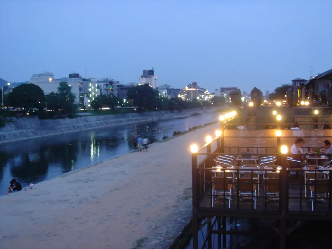 Lantern-lit wooden restaurants along the Kamogawa river at dusk in central Kyoto