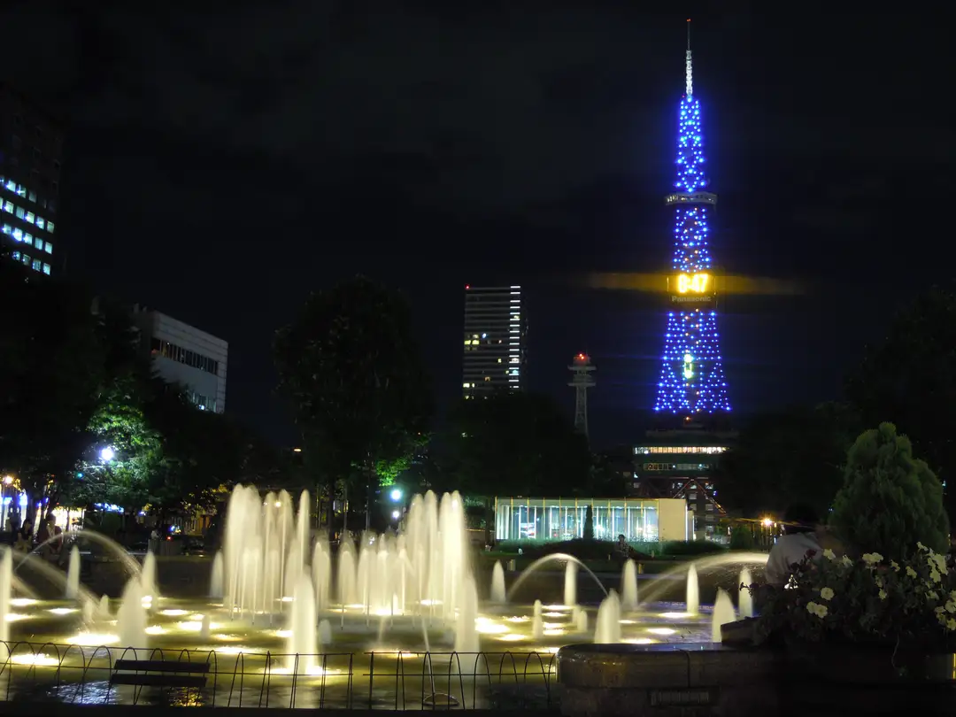 Sapporo TV Tower lit above the fountains of Odori Park, the green spine of the planned city, at night