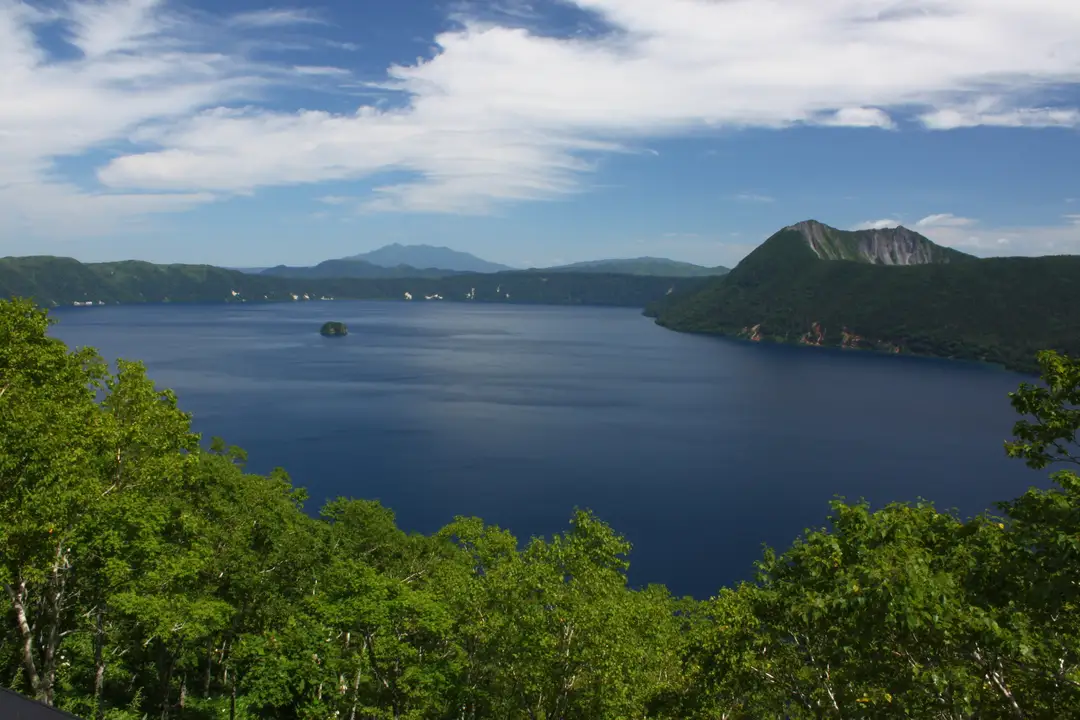 The deep-blue caldera water of Lake Mashu ringed by forested slopes in eastern Hokkaido