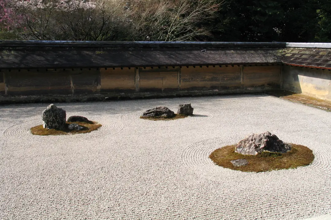 The raked white gravel and moss-ringed stones of the Zen rock garden at Ryoan-ji, Kyoto