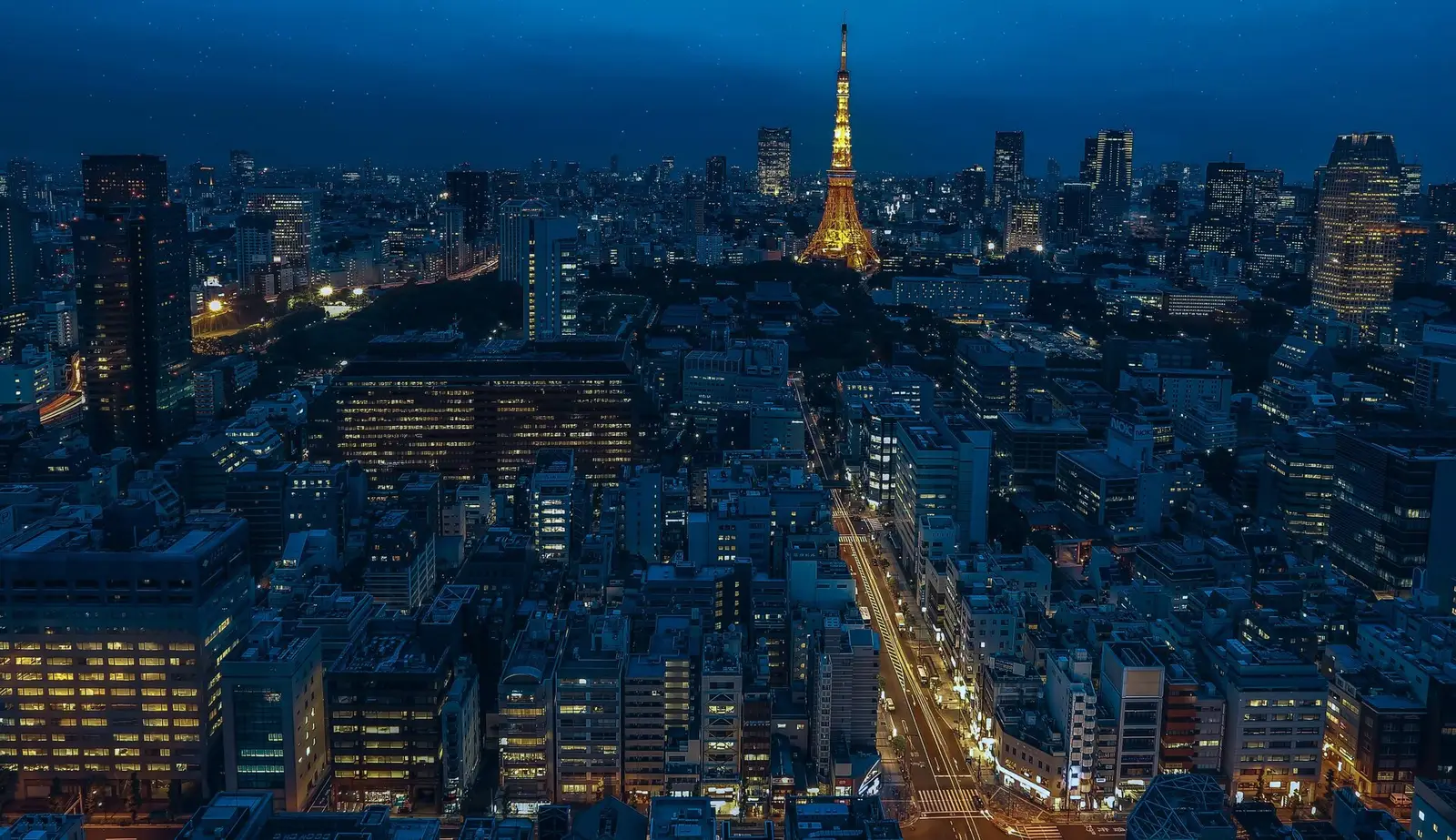 The Tokyo skyline at dusk with Tokyo Tower glowing among the buildings