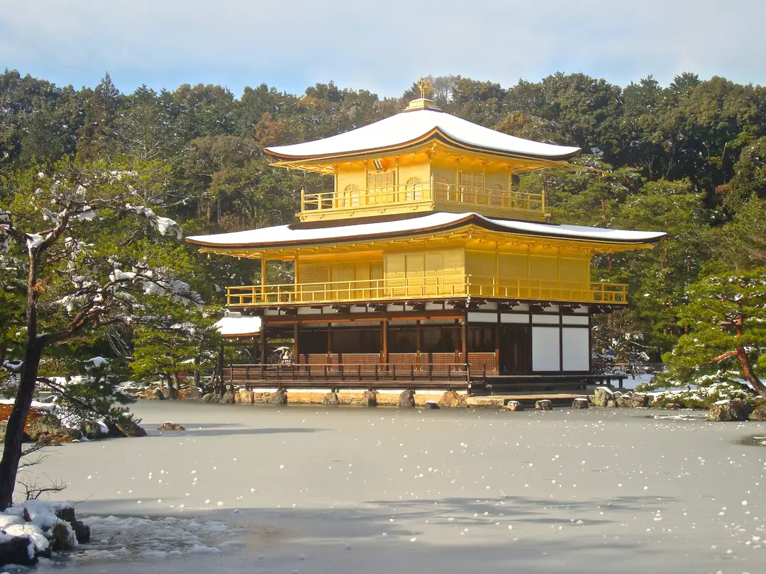 Snow settled on the roofs of Kinkaku-ji, the Golden Pavilion, above its frozen pond in Kyoto